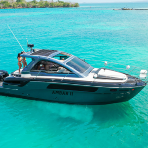 Port-side profile of the Amber II Bavaria Sport 35 ft yacht cruising in clear blue water near the Rosario Islands.